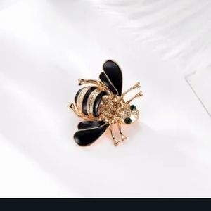 Bee broach. Gold with green eyes.
